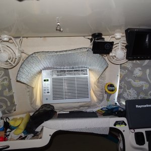 Air conditioner with "skirt in opening window. Above is Sirius radio, to right is rear view monitor with fan.  II am going to move monitor outboard and free up fan to be more versatile