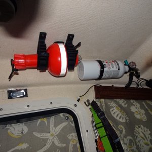 Rear of cabin upper:  Electronic SOS flare, fire extinguisher, Red LED light In center. The window coverings are in down position and covering snapped on the door.  Headlights are hung on hook.  Other flash lites are in holders.