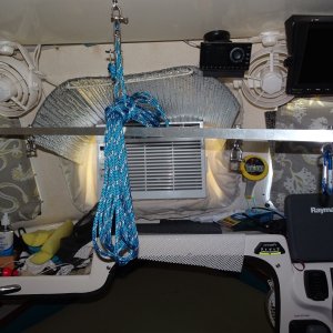 spreader bar in position to. hoist air conditioner.  The outer carabiners are used for hoisting the dinghy, the inner D shackles go over the handles of the window AC unit.  The shelf above has two pieces of 1 1/2" aluminum angle to take the load of the 6 part block and tackle.The shelf was re-enforced with aluminum "L" bracket.