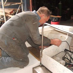 Shipwright Bob Tuckee working on the starboard/aft cover (lid) next to motor well and aft of cockpit seat/locker