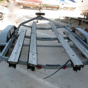 Trailer, as purchased.  Boat was stored indoors on a rack; trailer was left outside to fend for itself.  I should post an "after" photo as it is much improved now!  New bunks and carpet, new "half moons" on the fenders, new disc brakes, new actuator, new rollers, new winch and strap, new tires, new taillights and wiring, new spare.  Or to put it another way: Same frame ;)