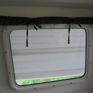 Roll up and tie window curtains.  Held down with Velcro tabs.