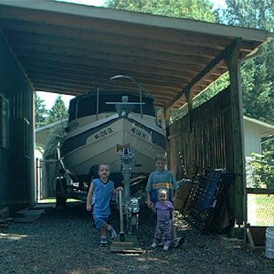 Three of my grandkids in front of the boat shed.
