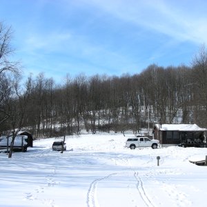 Cabin and outbuildings seen from the frozen lake.