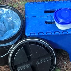 This a 2 gallon bucket with a water-tight "gamma" lid.  A double layer plastic bag goes under the lip and the lid screws down.  The folding stool is used to get in and out of the boat, but also brings the height of the toilet to a comfy position.