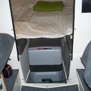 Dometic CF-50 fits easily in V berth with filler cushion removed. Height almost same as bunk height and refrig will support our weight as we enter/depart berth. We have never used this area for the head. It is kept on deck during day and placed just inside cabin door at night.