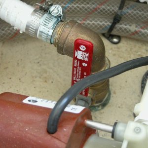 Media 'Sea Angel head seacock with its red handle in the open position. The two 'clear water lines at the top of the pix are the hot and cold lines to the shower and sink. The brown device at the bottom of the pix is the air conditioner's raw water pump motor frame.' in album 'Sea Angel view under step entering cabin. The base of the step(kick plate) is sealed to prevent any water from entering the cabin floor area under the 'dry deck'.'