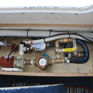2013-07-26 view of A/C and head thru-hulls with new fresh water flush setup.
The large red handeled seacock valve is for the head. 
The small red handeled valve is for the system bleeder, for the circulating pump. 
The white handeled seacock valve is for the air conditioner. 
The yellow handeled valve is for the fresh water  inlet to the air conditioner.
