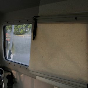 Media 'Shade is split to allow air circulation from forward side windows. Shade is made from canvas with dowel rods on top and bottom to allow easy rollup.' in album 'Copilot storage made from lucite sheet cut, heated and formed into a simple L shape. Mounted to forward bulkhead and seat box. Teak trim stiffens and covers the top edge.'