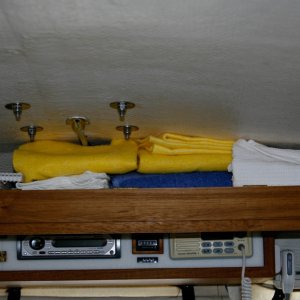 Media 'Console Shelf Door Down shows storage area for towels and misc books.' in album 'Copilot storage made from lucite sheet cut, heated and formed into a simple L shape. Mounted to forward bulkhead and seat box. Teak trim stiffens and covers the top edge.'