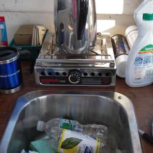 Shot of galley showing sink and stove behind it. Storage under stove.