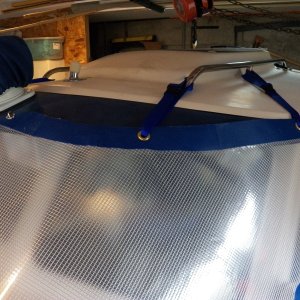 It is held on the cabin lip by Dot Common Sense fasteners in the center and webbing clips on the wings.