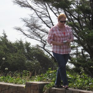 Carolyn walking the wall on the lookout point above Cannon Beach Oregon