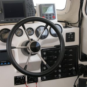 The 2 smaller guages above the helm are HONDA H2O press. gauges. Small switch above LENCO Trim Tab Control Panel is the winch control switch with the circuit breaker located to the right of the hand mic., above the VHF radio. The plastic hub has since been replaced with a beautiful piece of teak.