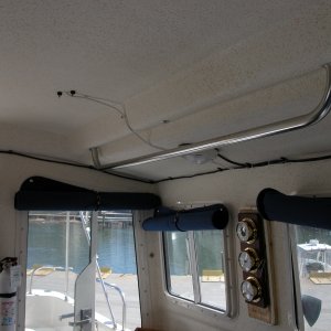 (Sea Angel) Port Side Grab Rail, Fire Extinguisher and WX Station. 

The WX Station is mounted on a hinged base so the clock battery can be changed. Two brass eyes are positioned in the side section with a brass 'pin' made from a toilet support arm, bent and cut to length with short line attached. The 'Sea Angel' name is mounted with a "Clear Mailing Label" designed for a laser printer and covered with acrlyic spray.