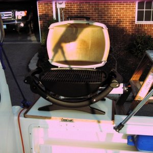 Table supports Weber Baby-Q propane gas grill