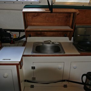 Media 'Covers are raised and helm seat pivots up to use galley. Hot items can be placed on ceramic tiles under helm seat. Small drop-down shelf inside forward cover is made of starboard trimmed in teak. Snap on elastic bands are handy for holding essentials (spelled COFFEE press) when underway.' in album 'Covers are raised and helm seat pivots up to use galley. Hot items can be placed on ceramic tiles under helm seat. Small drop-down shelf inside forward cover is made of starboard trimmed in teak. Snap on elastic bands are handy for holding essentials (spelled COFFEE press) when underway.'