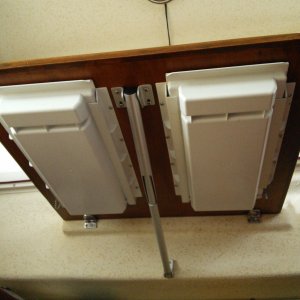 Underside of drop-down table.   A slide out plastic drawer has been installed on each side of the support bracket.  A small thru-bolt is inserted in the track and drawer towards the back of each drawer when not in use to keep it from opening and spilling the contents when underway or while trailering.