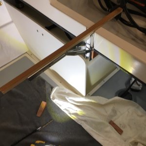 Installing the table hinges. Part of the table rests on the crossmember. The stick is just to ensure it's all level before I screw the hinges to the teak hinge mounts.
