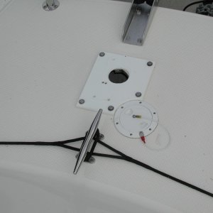 Changing from Vertical to Horizontal windlass presents some challenges.  First, cover the old, large hole. Drill some new holes and mount a Starboard spacer.  New windlass bolts through spacer and deck, 1.25" total thickness.  Round cap is for wash down hose.