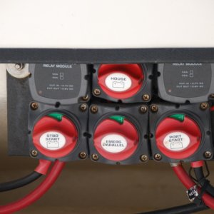 BEP 717A-100A 3 battery mounting at stern. 
Relays can be seen, top row, at the left and right of the House battery switch. 
Emergency Parallel switch for the 2 start batteries is in the bottom row, middle, directly below the House selector switch. 
These switches are all in the "ON" position. 
This allows GUEST 2610A Charger to charge the 3 on-board batteries. 
The how: the charger is wired to the Starboard and House batteries directly, allowing the Port to be charged via the Parallel Switch. 
When  either Start battery reaches 13.7V the VSR will cut in, the charger can thus support them all.