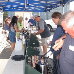 cooking tent - many hands make light work - pancakes, sausages, bacon on camp stoves