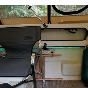 Coleman chairs are comfortable and have a handy pull up shelf. Chairs are stowed under gunnels when trailering.Also note the cleat added inside the cockpit at the end of the gunnel tray. This is used to tie off and adjust the middle fender and to tie off the forward and aft docking lines so that they are in hand as we step onto the dock.
