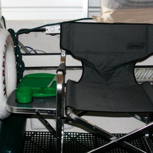 Starboard side view of Coleman chair with fold down side table. Life ring on the rear cabin bulkhead is ready to grab.