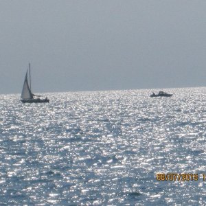 Media 'The stickboat and the stinkpot cross courses.' in album 'A sailboat with its tender anchored behind the breakwall.'