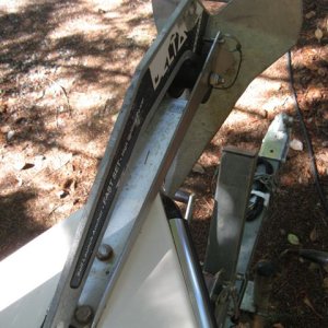 Anchor retainer using quick release pin to allow removal of anchor line from bow roller. Neoprene pad prevents scratches.