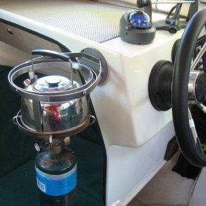 Forespar Mini Galley gimballed propane stove with kettle mounted next to helm; provides heat in a pinch