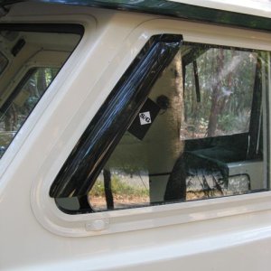 Vent visor installed on sliding windows-- cut down from generic car visor (a Bronco model, I think). $40 for a pair.