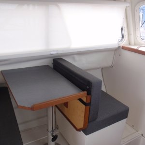 Dinette w/Nav seat facing fwd; storage in box and floor below; window curtain rolled down