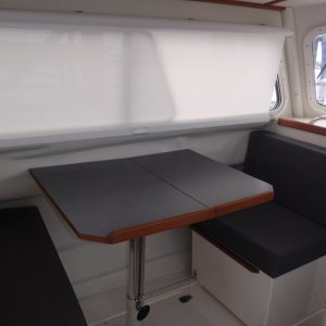 Dinette w/Nav seat facing aft, table up, storage in sliding box below and under floor