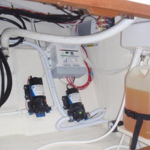 Under galley storage w/battery charger, water pumps, Wallas diesel fuel tank w/head shower plumbing above tank