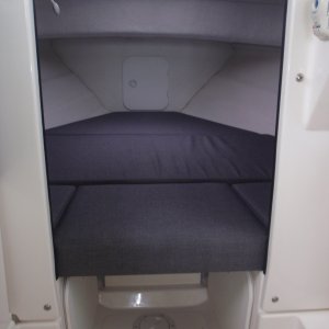 V berth w/storage floor cabinets port/stbd, bilge access inspection plate aft of water tank, no wall shelving, extra storage under forward most cushion, access to anchor locker.  Privacy curtain not visible.