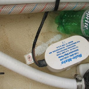 Screw holes for bilge pump in cabin step sump, ground out and filled with epoxy, so no screws into core