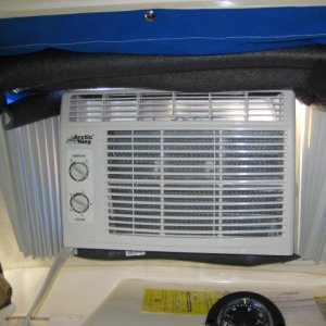 Inside of cabin with 5,000 BTU air conditioner and sunbrella snapped in place.  The fan fold \"wings\" from the airconditioner are snapped to the window frame, and the air conditioner is resting on pipe insullation foam, and pipe insullation foam to seal the top and sides of the opening.