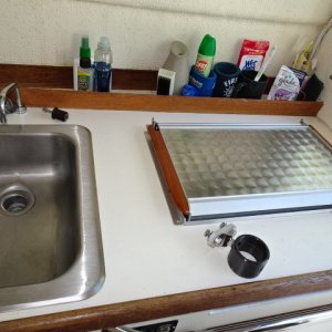Wallas stove, sink (water foot pump or electric momentary switch).  support for Garhauer davit, teak divider for sundry items in back of counter