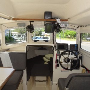 Note dual fans, extra radio speaker, radar and radio hung from electronics shelf, and GPS plotter/ depth sounder on console.