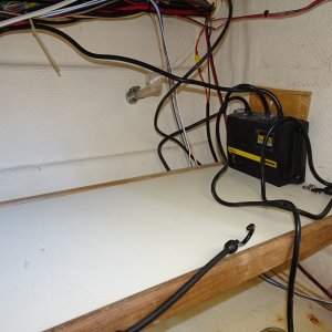Under galley storage shelf and battery charger