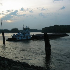 Small tow with single barge at dusk