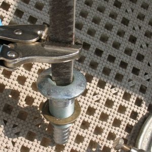 "Tool" for removing through hull since I didn't have the proper tool on hand.  Old junk file to catch on the "ears" inside the through hull and vise grips to hold file.