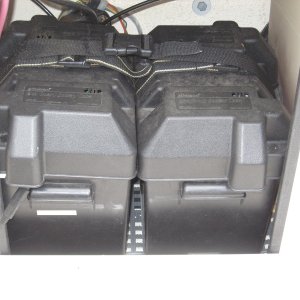 start and house battery on dri deck and strapped to epoxy bonded ss loops to floor, cables long enough to bring batteries out onto cockpit floor to maintain