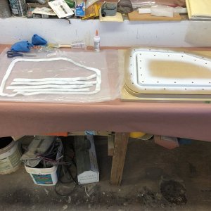 First I made the lid bases. At right of photo I've assembled the four mold parts for the lid base for the starboard locker. On left of photo are strips of 1708 ready to wet out and lay in the mold.