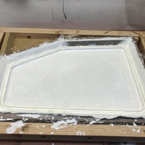 Here the mold has been layed up with fiberglass, the o-ring channel has been inserted, and a strip of stainless steel has been inserted as backing for hinges. Also note that the whole assembly is resting in a box. This was done so that a jig could be clamped to the top edges of the box. This jig has strips of MDF on it that were tied directly to the o-ring channel with monofilament line, to ensure the the o-ring channel was positioned exactly flat, with respect to the top of the lid. The monofilament line was then simply cut to remove the jig once the epoxy was cured. Sorry I neglected to photograph this step.