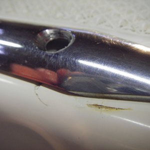 Screw removed and SS piece moved to show gel coat crack and wear spot needing repair on port gunnel top plate.