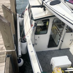 Beside Michigan Island Dock in 2-3 ft seas, winds into port side, ball fender against climbing ladder