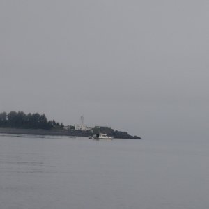 Discovery & whale in front of Five fingered Island lighthouse.  At least 30 humpbacks around us there