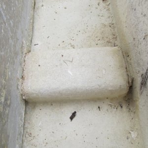 close-up of spacer.  Appears to be metal. Top left you can see corrosion and worn area.